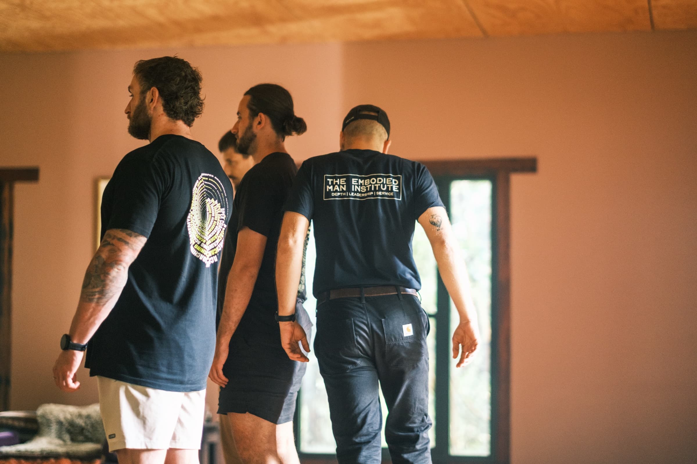 Men in The Embodied Man Institute shirts moving through the work